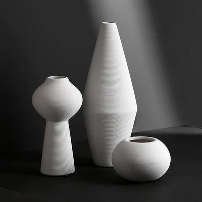 Moderne handgemaakte droge bloemenvase in witte keramiek voor tafelversiering